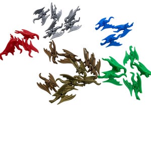 May include: A collection of small, dragon-shaped figurines in various colors. The figurines are red, silver, blue, green, and bronze. Each dragon has outstretched wings and a detailed body, perfect for crafting or collecting.