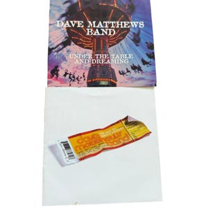 May include: Album cover for Dave Matthews Band's "Under the Table and Dreaming" with a carousel image. Below, a ticket stub with "Dave Matthews Band" and "The Best of What's Around" text is visible.