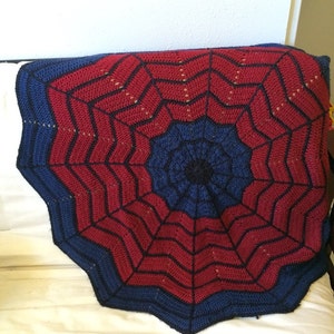 May include: A red and blue crocheted blanket with a spiderweb design.