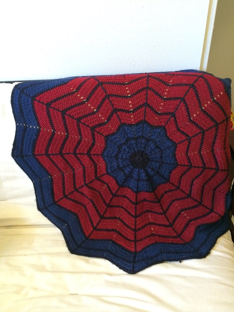 May include: A red and blue crocheted blanket with a spiderweb design.