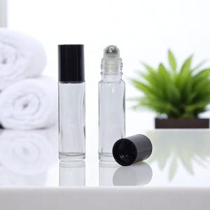Botella de vidrio transparente con rodillo cosmético de 10 ml, con bola de metal y tapa negra para aceites esenciales, para spa y piel.