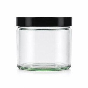 May include: A clear, cylindrical glass jar with a smooth, transparent body and a flat, solid black screw-top lid. The container features a wide mouth and a sturdy, thick base, providing a simple and functional design for storage and organization.