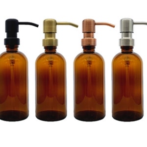 May include: Four amber glass bottles with different coloured pump tops. The bottles are all the same size and shape. The pump tops are black, gold, copper, and silver.