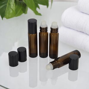 Botella de vidrio ámbar con rodillo cosmético de 10 ml, con bola de plástico y tapa negra para aceites esenciales, para spa y piel.