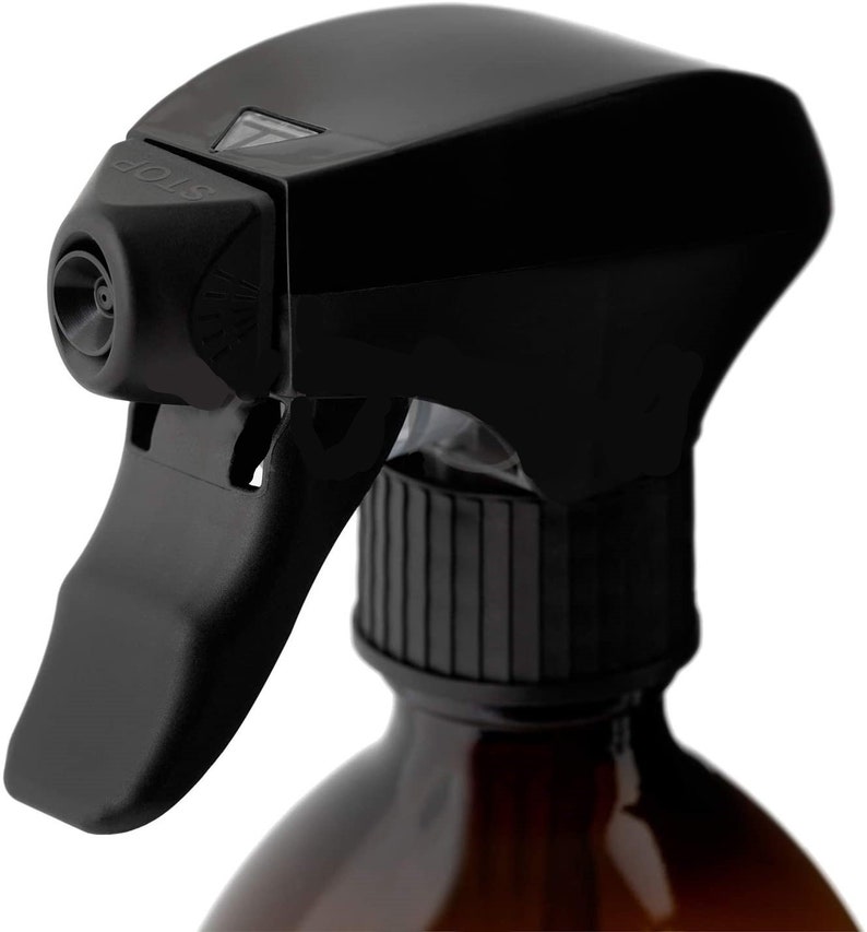 K&ouml;nnte beinhalten: Schwarze Spr&uuml;hflasche aus Kunststoff mit Spr&uuml;hkopf und transparenter D&uuml;se. Die Flasche hat einen schwarzen Verschluss mit geriffeltem Design. Der Spr&uuml;hkopf ist mit dem Wort "STOP" beschriftet.