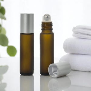 Botella de vidrio ámbar esmerilado con rodillo cosmético de 10 ml, con bola de metal y tapa plateada mate, ideal para aceites esenciales, para spa y uso a granel.