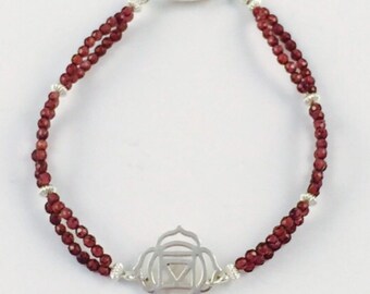 Sterling silver root chakra bracelet with faceted garnet beads.
