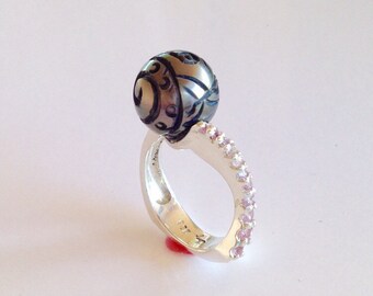 Anillo de plata esterlina con perla de Tahití negra tallada por el diseñador y zafiro rosa.