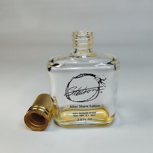 Pu&ograve; includere: Flacone di lozione dopobarba Stetson in vetro trasparente con tappo dorato. Il flacone ha una forma quadrata con bordi arrotondati e tappo a vite. L'etichetta recita "Stetson" e "After Shave Lotion", volume 59 ml.
