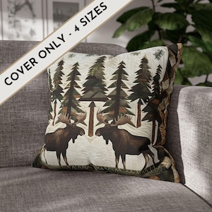 May include: Square cushion cover with a forest scene featuring two moose and tall pine trees. The cover has a quilted design with a cream background and brown, green, and tan accents. The text "COVER ONLY - 4 SIZES" is printed on the image.