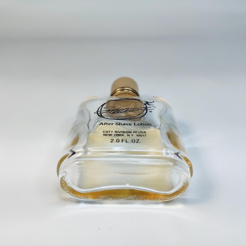 Pu&ograve; includere: Una bottiglia di vetro trasparente di lozione dopobarba Stetson con tappo color oro. La bottiglia ha una forma rettangolare con bordi arrotondati e contiene un liquido color ambra chiaro. L'etichetta recita "After Shave Lotion" e "2.0 FL. OZ."