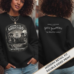 May include: Black sweatshirt with a double-sided print. The front features a graveyard scene with the text "Welcome to the Graveyard" and "Are you ready to dance?". The back displays "Silly Symphony" and "The Skeleton Dance".