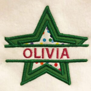 Può includere: Stella verde su sfondo bianco con pois colorati. Il nome Olivia è scritto in rosa al centro della stella.