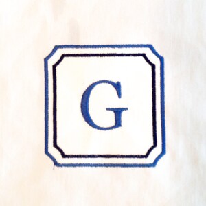 Elegante één eerste monogram op plein met afgeschuinde hoeken.  Kan worden gestikt met of zonder stoffen weefsel. 2 maten.