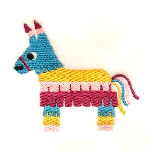 May include: A blue and yellow embroidered pinata shaped like a donkey with a pink tail. The pinata has a red fringe around the middle and pink and yellow fringe around the legs.