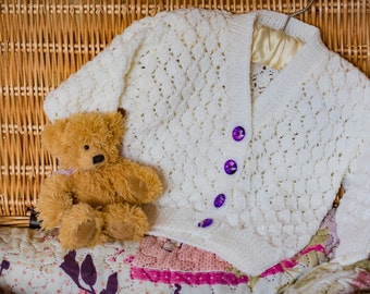 V-Hals-Baby-Strickjacke In glitzernden weißen Garn mit lila Glanz Tasten. Handgestrickt aus weichem Acryl funkeln DK-Garn. 18 Monaten Größe 24" Brust