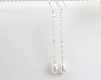 May include: A pair of long silver chain earrings with a small pearl at the top and a larger pearl at the bottom of each chain.