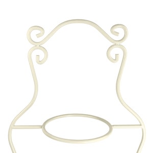 May include: White metal cake stand with a round base and ornate scrollwork details.