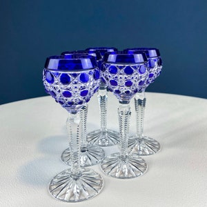 Puede incluir: Juego de cuatro vasos de chupito de cristal azul cobalto con dise&ntilde;o de cristal tallado. Los vasos tienen un tallo transparente y una base transparente.