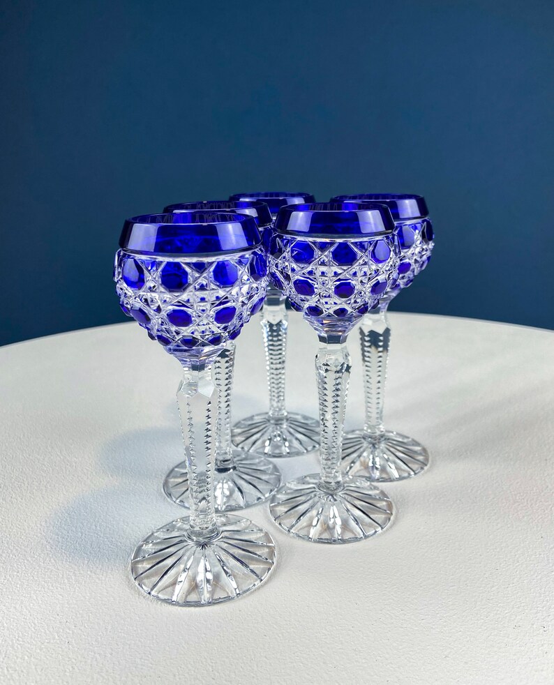 Puede incluir: Juego de cuatro vasos de chupito de cristal azul cobalto con dise&ntilde;o de cristal tallado. Los vasos tienen un tallo transparente y una base transparente.