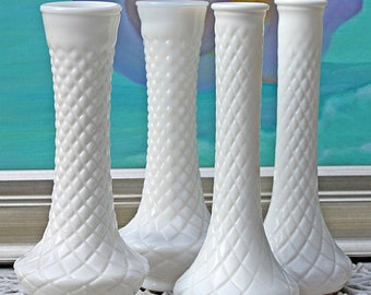 Puede incluir: Juego de cuatro jarrones de leche de vidrio blanco con un patrón de diamante. Los jarrones son altos y delgados con una base acampanada.