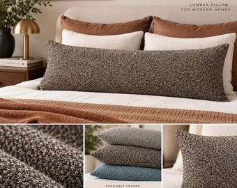 May include: A long rectangular lumbar pillow featuring a textured, multi-tonal brown and black bouclé fabric. The pillow is displayed on a bed with other pillows and includes a close-up view of the fabric weave and a color palette of blue, brown, and rust.
