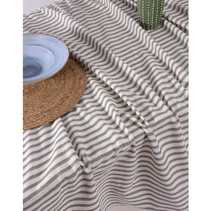May include: A white and gray striped tablecloth with a woven texture. The tablecloth is made of cotton and is perfect for a casual dining setting.