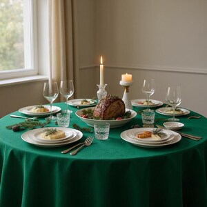 May include: A festive dining table set for a holiday meal. The scene includes a green tablecloth, white plates, wine glasses, candles, and a centerpiece of roasted meat. The table is set for a special occasion.