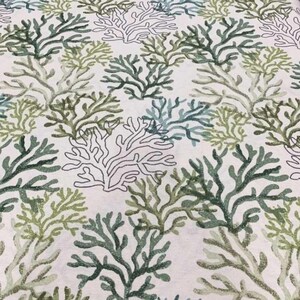 Pu&ograve; includere: Un tessuto con un motivo ripetuto di disegni di barriera corallina in tonalit&agrave; di verde e verde-blu su sfondo bianco. I disegni dei coralli variano per dimensioni e dettagli, creando un aspetto strutturato. Il tema generale &egrave; marino e costiero.