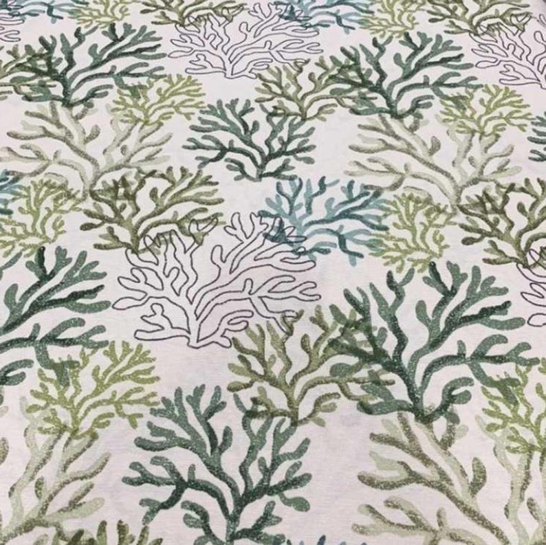 Pu&ograve; includere: Un tessuto con un motivo ripetuto di disegni di barriera corallina in tonalit&agrave; di verde e verde-blu su sfondo bianco. I disegni dei coralli variano per dimensioni e dettagli, creando un aspetto strutturato. Il tema generale &egrave; marino e costiero.