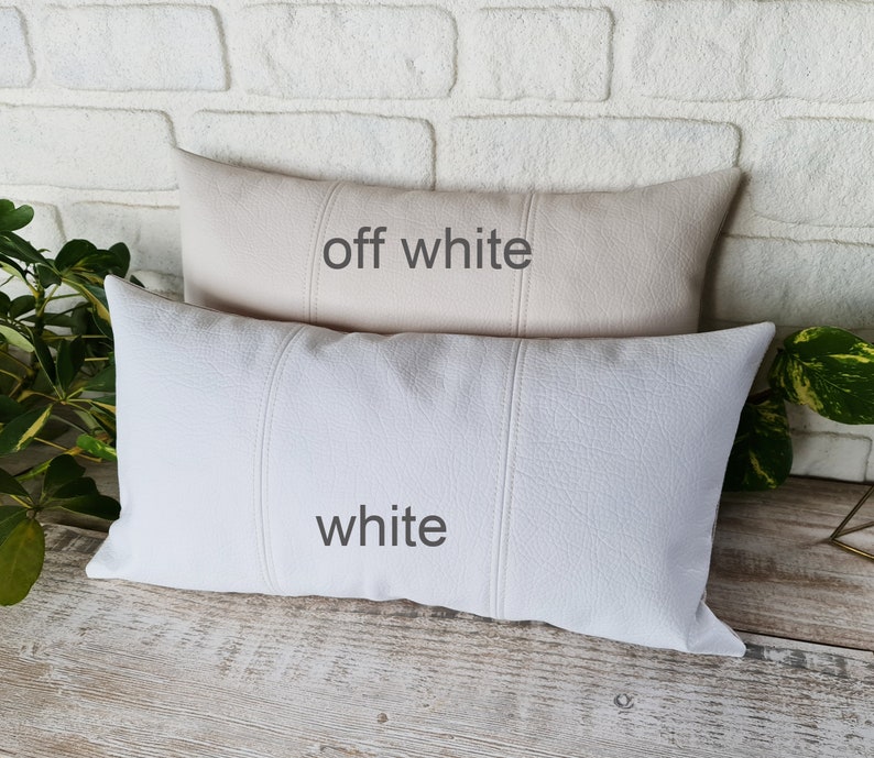 May include: Two decorative throw pillows, one off-white and one white. Both pillows have a textured fabric and are rectangular in shape.