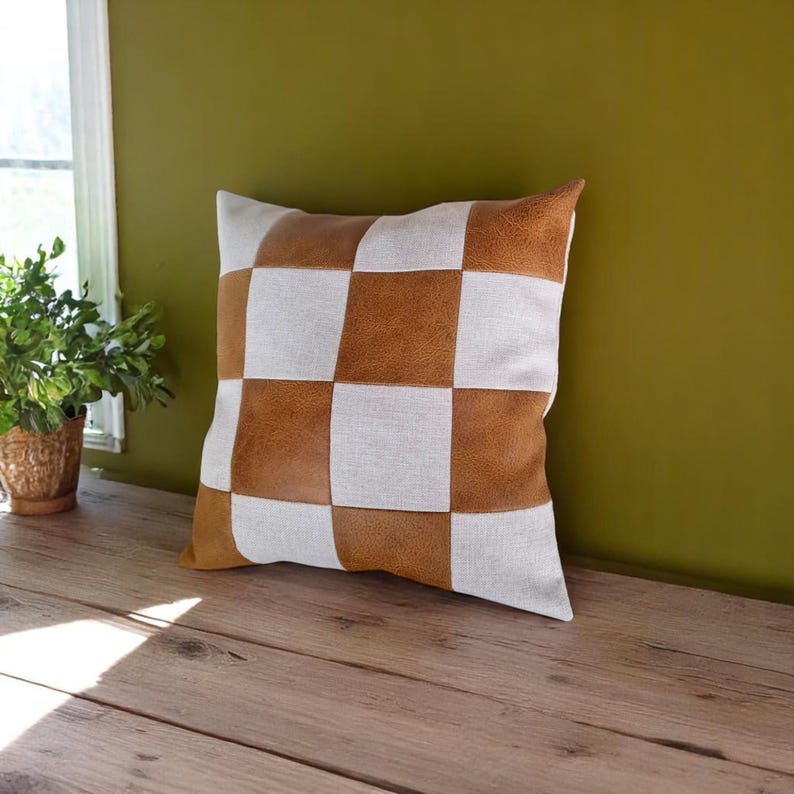 May include: A brown and white checkered throw pillow with a square pattern. The pillow is made of a soft, textured fabric.