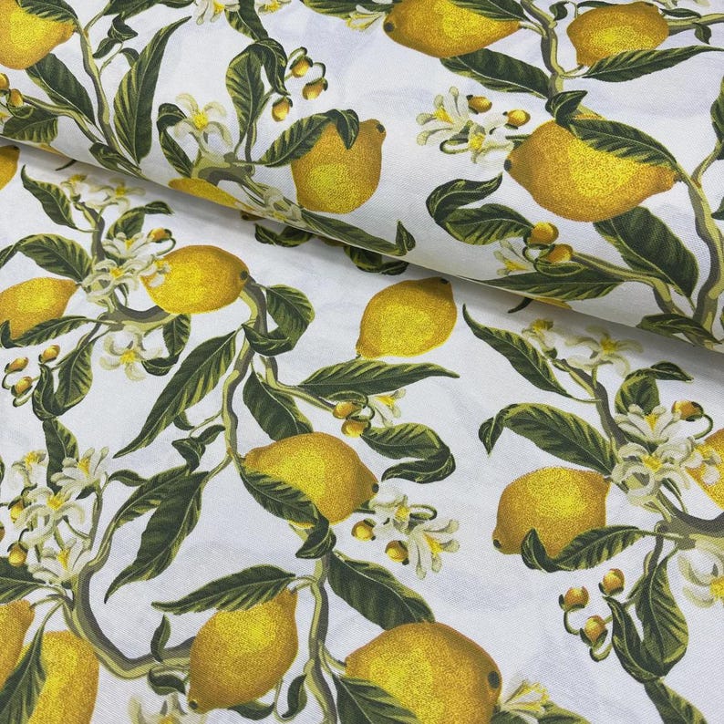 May include: White fabric with a repeating pattern of yellow lemons, green leaves, and white blossoms. The lemons are detailed with shading, and the leaves and blossoms are scattered across the fabric.
