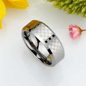 May include: A silver tungsten carbide ring with a checkered pattern. The ring is beveled and has a brushed finish.