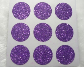 May include: A sheet of purple glitter stickers, with twelve round stickers arranged in three rows of four.
