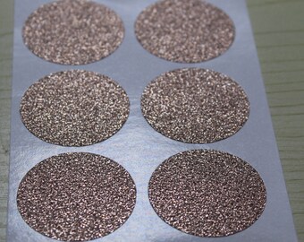 May include: A sheet of six round, pink glitter stickers. The stickers are arranged in two rows of three.