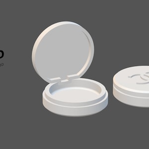 May include: A white, round compact with an open lid and a closed lid. The closed lid features a double-C logo. The text "AC3D Art-chitecture3D Miniatures" is in the upper left corner. The background is a solid gray.