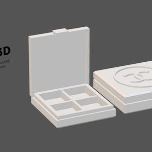 May include: A white, open square box with four compartments next to a closed box with a logo on top. The text "AC3D Art-chitecture3D Miniatures" is in the upper left corner. The boxes are on a gray background.