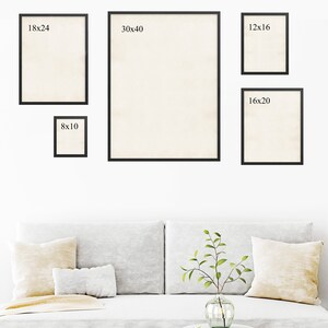 May include: Five black picture frames of different sizes hanging on a white wall above a white couch with two pillows. The frames are labeled with their dimensions: 18x24, 30x40, 12x16, 8x10, and 16x20.