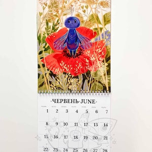 Op de afbeelding: Een kalenderpagina voor juni met een illustratie van een blauw insect met rode en blauwe vleugels op een rode bloem. De kalender toont data en het woord "Juni" in het Engels en Oekra&iuml;ens.