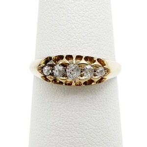 May include: A gold band ring with five small round diamonds set in a scalloped design.