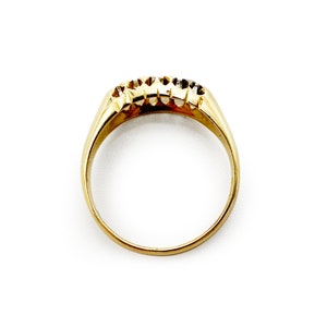 May include: A gold band ring with three small diamonds set in the band.