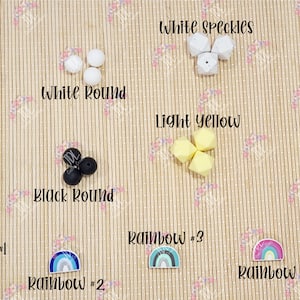 May include: Assortment of silicone beads in various colors and shapes, including marble, white speckles, white round, black, black round, light yellow, yellow, and rainbow designs.