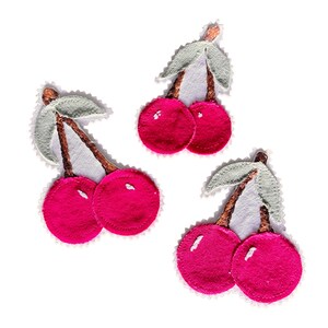 May include: Three embroidered cherry patches featuring vibrant pink circular fruit, brown stems, and light green leaves. Each patch has a white stitched border and a small white highlight on the surface of the cherries, creating a textured appearance.