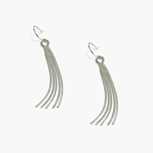 Puede incluir: Un par de pendientes colgantes plateados. Cada pendiente presenta un pequeño diseño circular en la parte superior, adornado con pequeños adornos, desde el cual caen en cascada múltiples hebras de delicadas cadenas. Los pendientes están diseñados para usarse con un gancho.