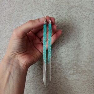 Très longues boucles d'oreilles avec perles turquoises et chaines pendantes.