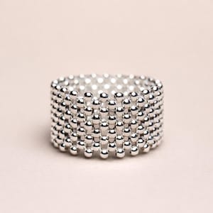 Könnte beinhalten: Ein Set aus drei Keramikbechern mit gesprenkelter, matter Oberfläche. Die Becher sind in Creme-, Hellgrau- und Dunkelgrautönen gehalten. Jeder Becher hat ein schlichtes, minimalistisches Design.