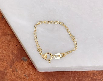 May include: A gold chain bracelet with a lobster clasp closure.