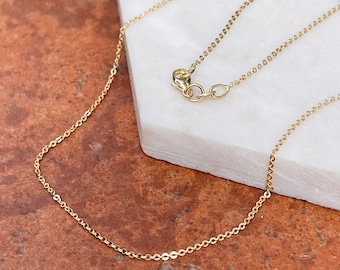 May include: A delicate gold chain necklace with a lobster clasp closure. The chain is made of small, linked circles.