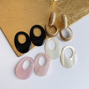 Orecchini pendenti in oro giallo 14 carati, con fondo Omega ondulato a coste lucide e pendente in oro, pietra preziosa in onice e madreperla, quarzo rosa.